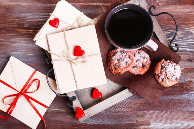 Cartas de amor con café y galletas sobre fondo de madera