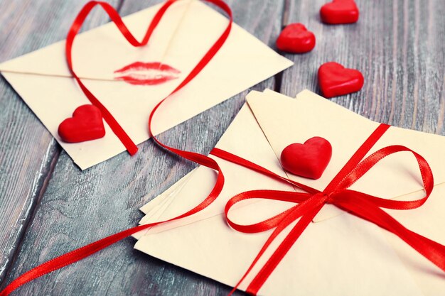 Cartas de amor con cinta roja sobre fondo de madera