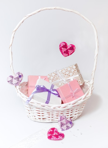Foto cartas bonitas brancas e cor-de-rosa com laços e fitas e corações em cores pastel em cesta branca
