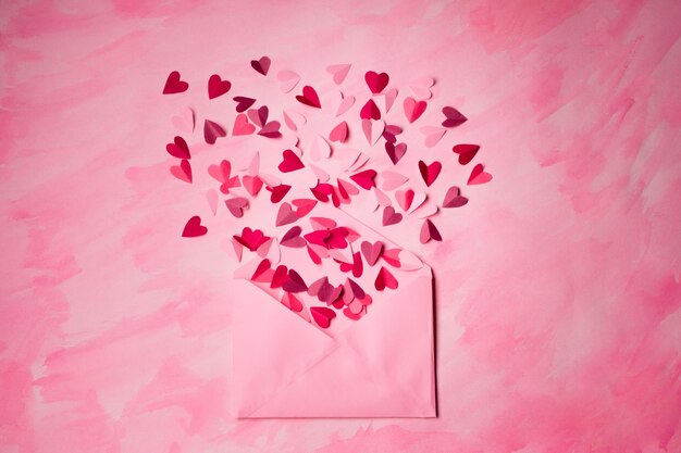 Cartas de amor. envelope rosa com corações vermelhos dentro de fundo rosa.