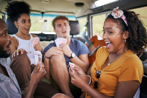 Cartas de jogar viagem e amigos na van ganhando e empolgados com a aventura, férias e jogos para jovens, estilo de vida Diversidade grupo de pessoas acampando e vencedor com jogo de cartas em um carro de caravana