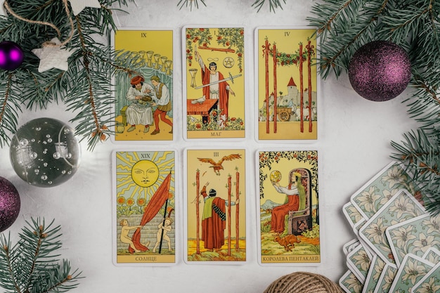 Cartas de tarô espalhadas com a face para cima na superfície de concreto branca com árvore de Natal e decorações. Minsk, Bielo-Rússia, 19.11.2021