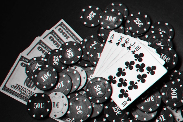 Cartas con escalera real en un montón de fichas y dólares en un juego de póquer. Foto en blanco y negro con efecto de falla.