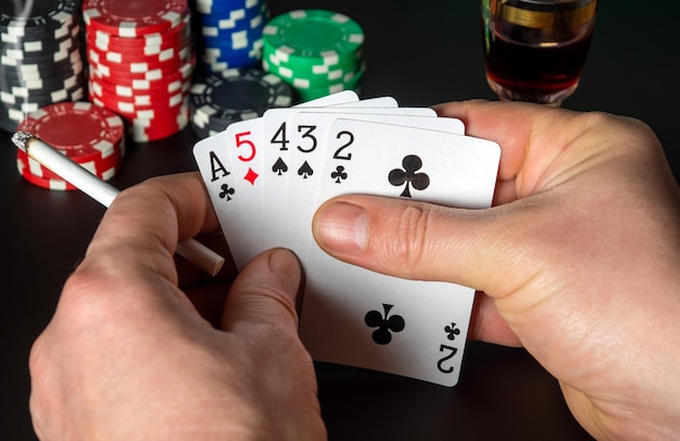 Cartas de póquer con combinación de cartas altas. Cerca de las manos de un jugador está sosteniendo naipes en el club de póquer