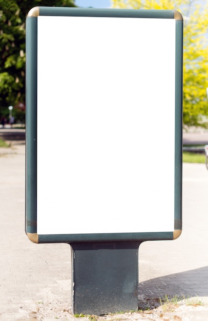 Cartaz de outdoor de rua vertical de publicidade em branco sobre fundo de parque da cidade.