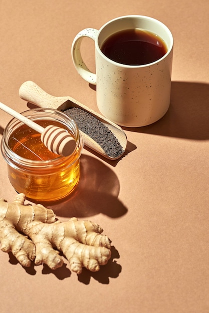 Foto cartaz minimalista - composição com chá, limão, mel e gengibre em um fundo marrom. chá curativo para resfriados.