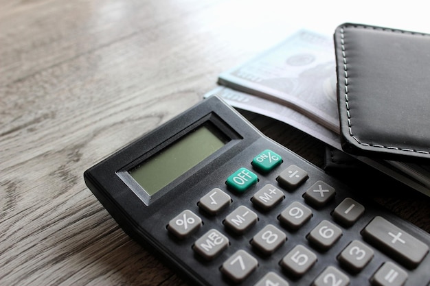 Carteira de calculadora e dinheiro na mesa de madeira com espaço de cópia Conceito de negócios e finanças