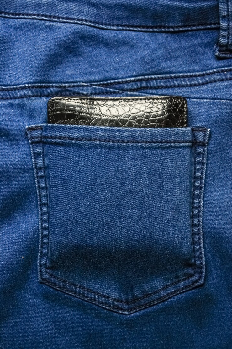 Carteira de couro preto nas costas com bolso jeans textura.
