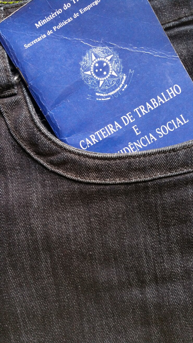 Carteira trabalhista brasileira no bolso da calça jeans.