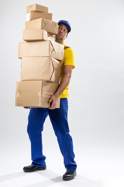 Carteiro brasileiro em um fundo branco entregando um pacote. copie o espaço.