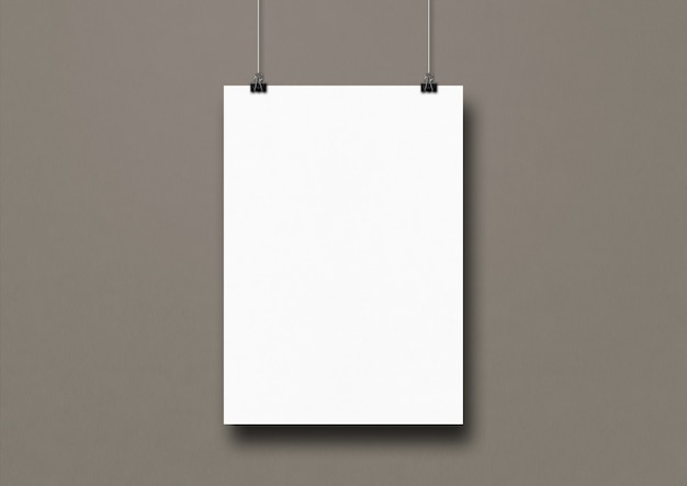 Cartel blanco colgado en una pared gris con clips.