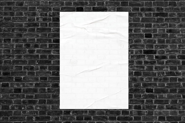 Cartel blanco en una pared de ladrillo negro