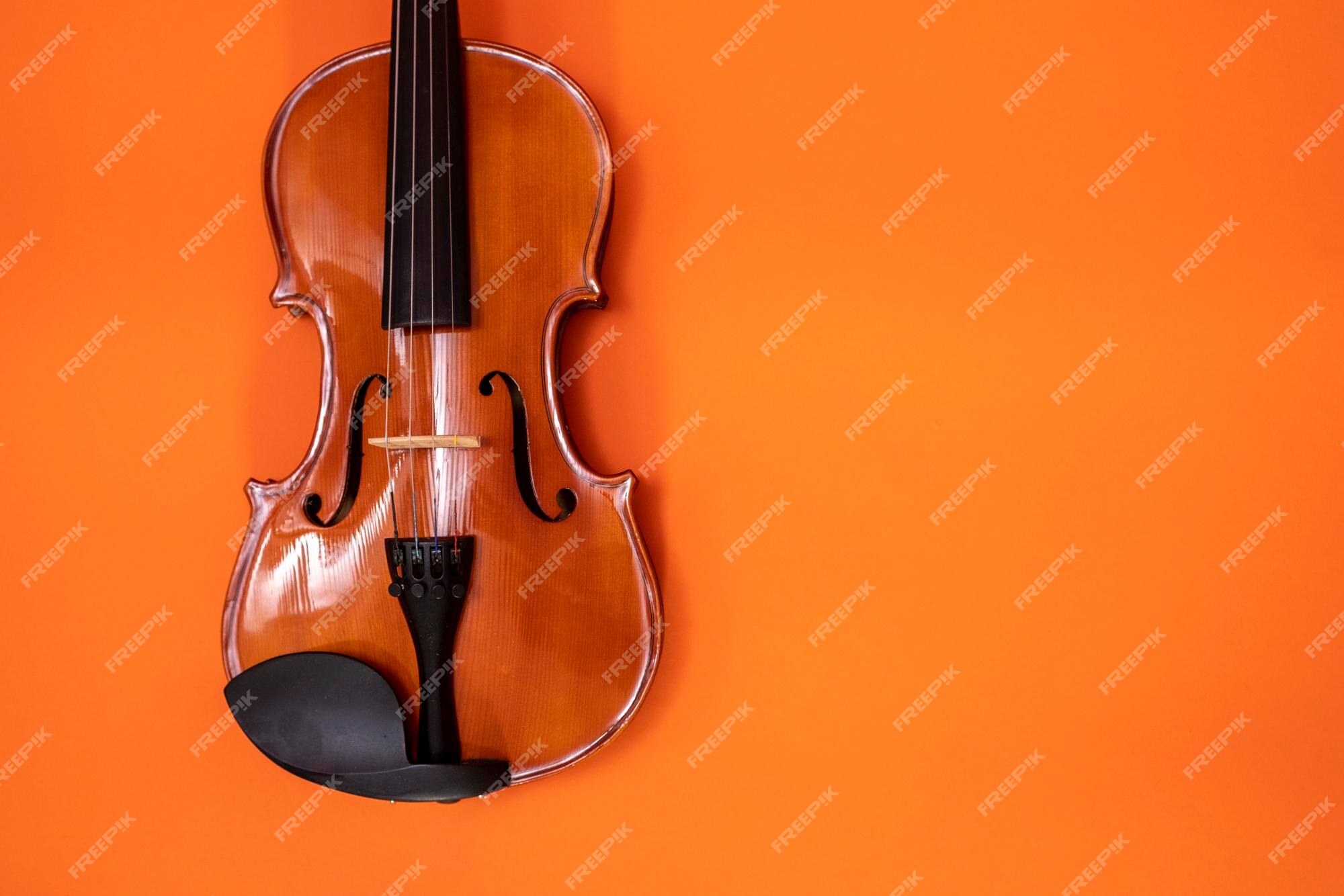 Cartel de concierto de música clásica con violín de color naranja sobre amarillo con espacio de copia para | Foto Premium