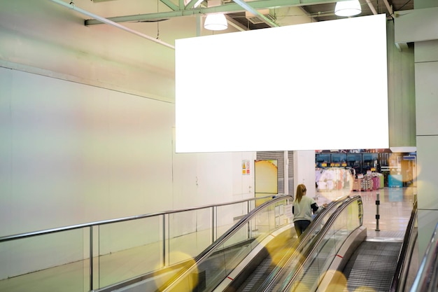 Cartel horizontal grande en blanco en lugares públicos Una valla publicitaria cerca de la escalera mecánica en el edificio del aeropuerto