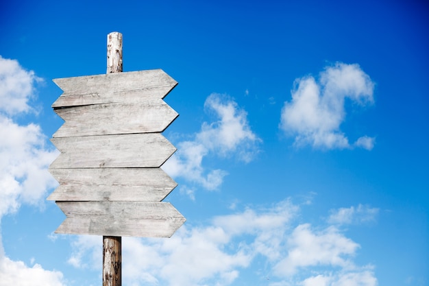 Cartel de madera sobre un fondo de cielo azul con nubes