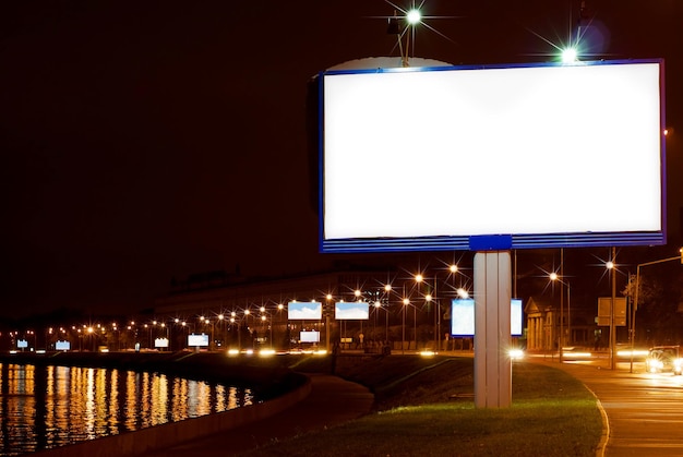un cartel que dice " carteles publicitarios " está iluminado por la noche