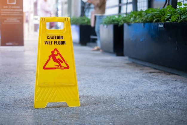 Cartel que muestra la advertencia de precaución piso mojado en el edificio de oficinas