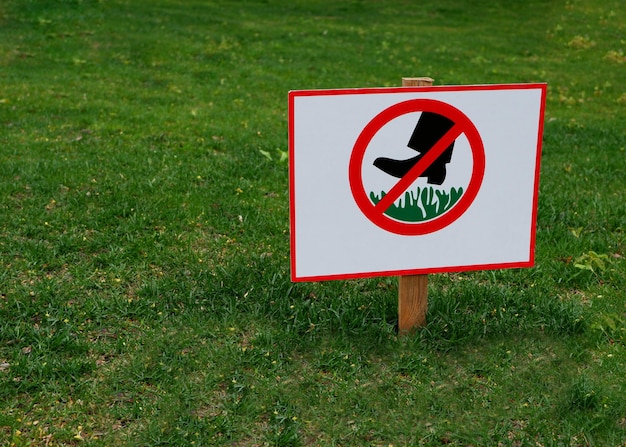 Foto un cartel que prohíbe caminar sobre el césped