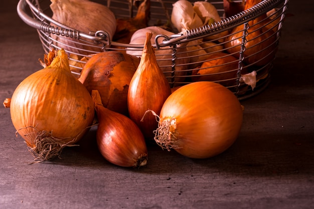 Cartel de una vieja canasta con cebolla, ajo y tomate para decorar la cocina