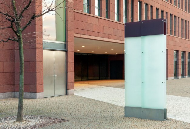Cartelera al aire libre de vidrio en blanco con espacio de copia en el edificio de oficinas moderno