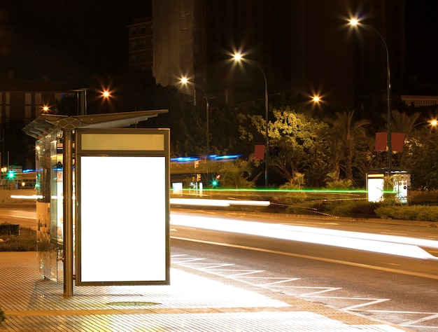 Cartelera con luz en el centro de la ciudad por la noche.