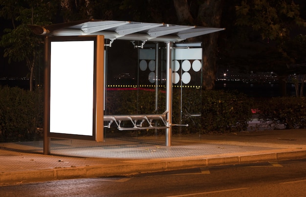 Cartelera con luz en el centro de la ciudad por la noche.