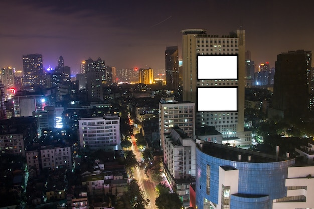 Cartelera publicitaria en blanco en el alto edificio, paisaje de la ciudad, mensaje de texto para comercial