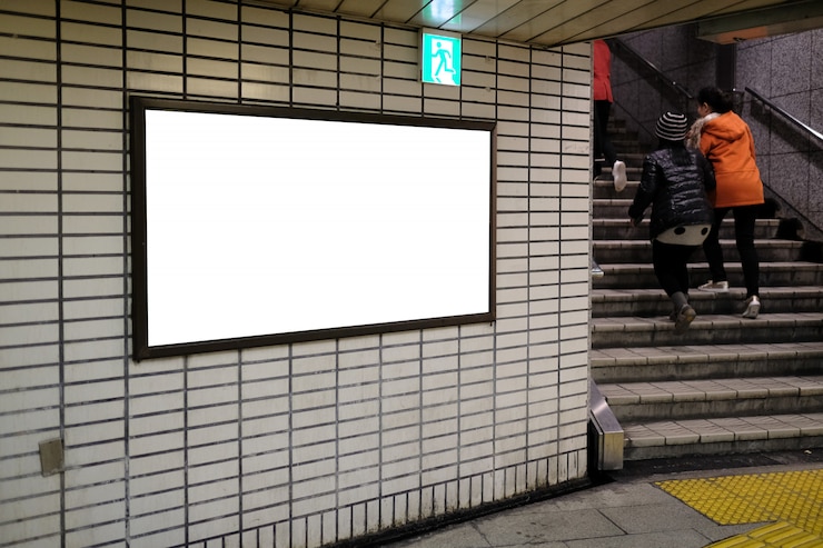 Foto cartelera publicitaria en blanco y señal de salida de emergencia en el aeropuerto