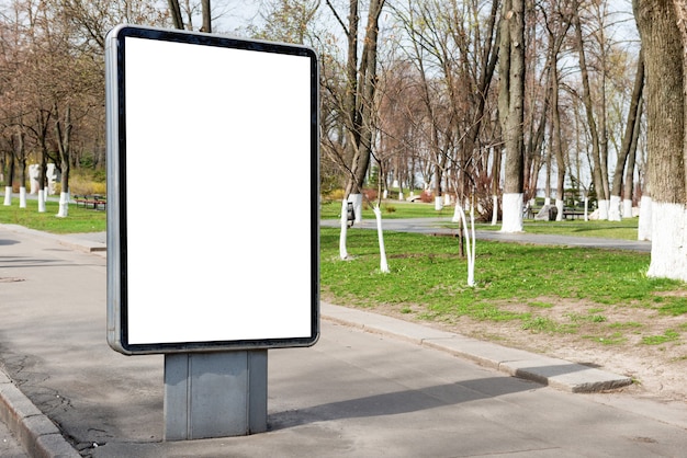 Cartelera vacía o caja de luz en la calle de la ciudad verde con fondo blanco aislado