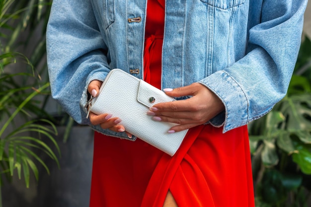 Foto cartera blanca en manos de la chica de rojo.