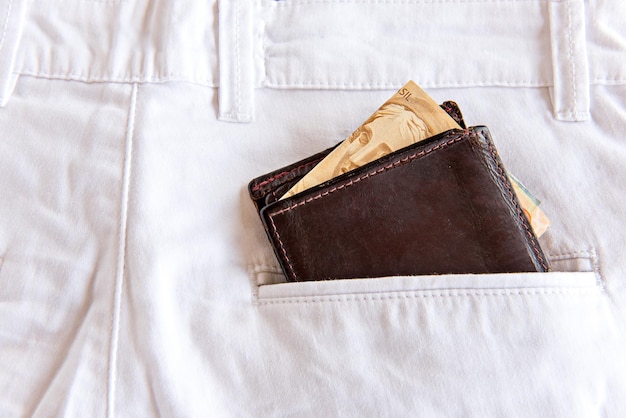 Cartera con dinero en bolsillo de jeans blancos