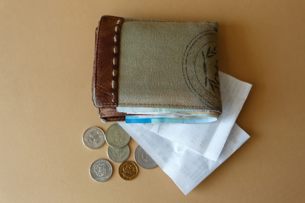 Cartera con dinero, monedas y cheque de caja de la tienda.