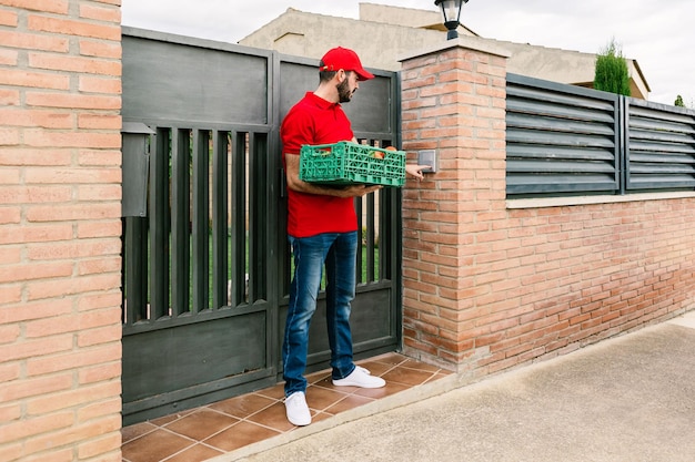 Cartero o repartidor que lleva la entrega de alimentos en cajas pequeñas al cliente en el hogar Servicio de entrega de alimentos y concepto de pequeña empresa