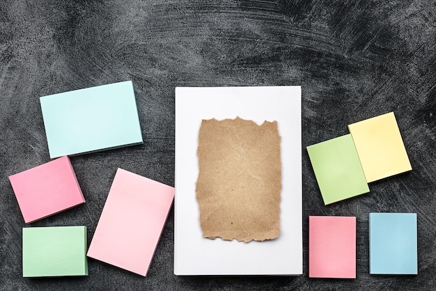 Cartões brancos em branco e adesivos coloridos em uma vista de fundo preto Preparação de um layout de papelaria de uma mesa de escritório