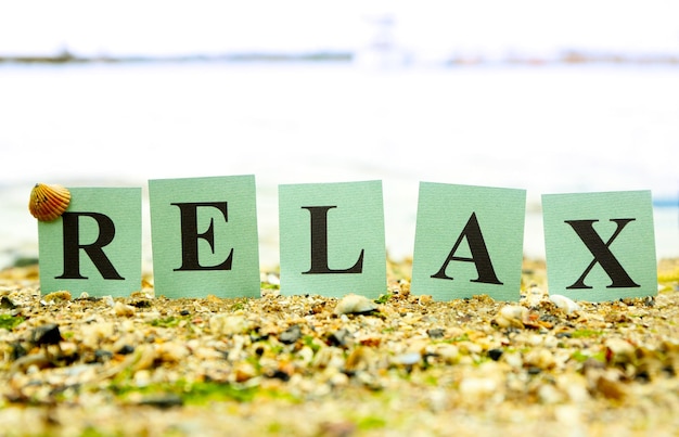 Cartões com a palavra impressa RELAX no fundo da praia