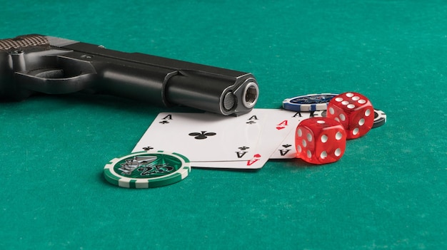 Cartões de fichas de pôquer e arma em um fundo verde Jogos de azar e entretenimento Cassino e pôquer