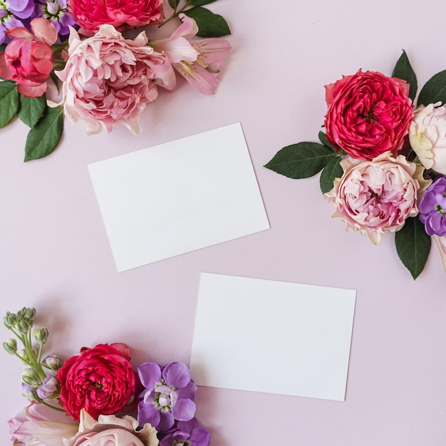 Cartões de folha de papel em branco com espaço de cópia de maquete botões de flores rosas rosa e vermelhas em fundo rosa fundo de modelo de mídia social de blog de marca de negócios estética mínima vista superior plana leiga