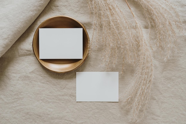 Cartões de papel em branco com espaço para cópia grama seca dos pampas em cobertor de linho bege neutro Vista superior plana leiga estética minimalista luxo boêmio conceito de marca de negócios