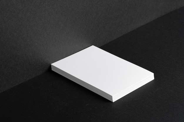 Cartões de visita brancos empilhados para identidade visual na tabela preta, copie o espaço