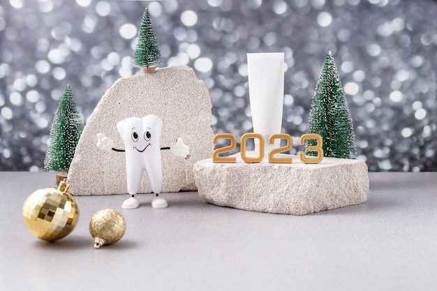 Cartoon-Modell eines Zahns mit den Nummern 2023 und einer Tube Zahnpasta auf einem Podium aus Stein