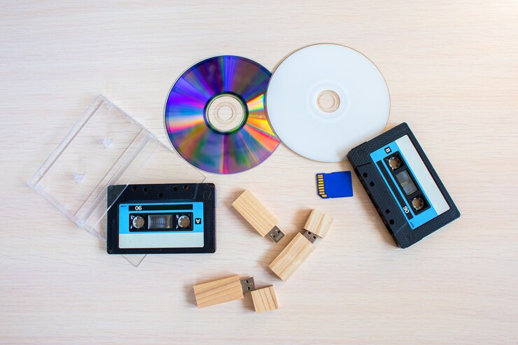 Foto cartucho de gravador antigo, pendrive e discos compactos juntos