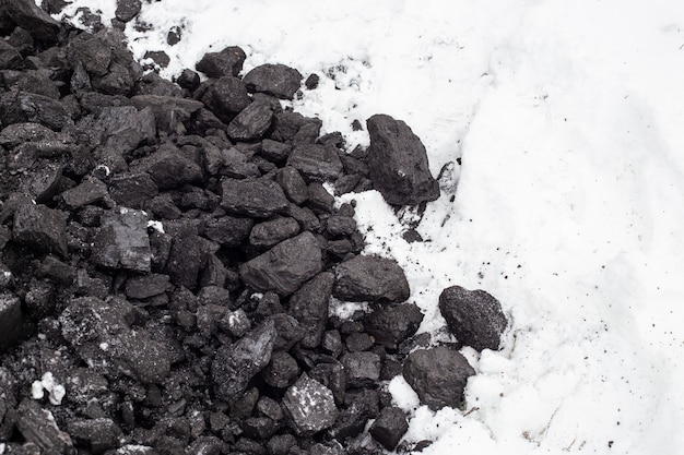 Carvão grosso na neve no inverno. manter altas temperaturas em caldeiras de combustível, sistemas de aquecimento doméstico. mineral combustível.