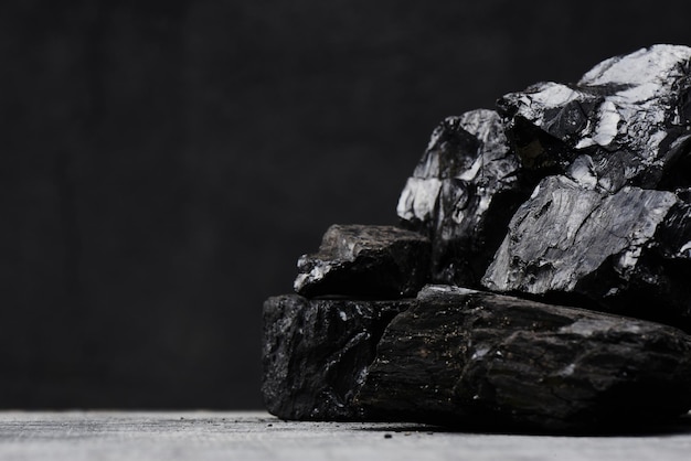 Carvão natural em um close up isolado de fundo preto. Extração de recursos minerais naturais.