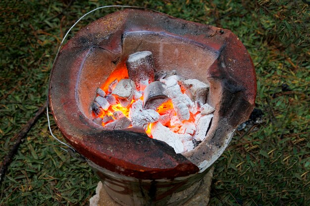 Carvão no fogão com fogo no jardim na tailândia