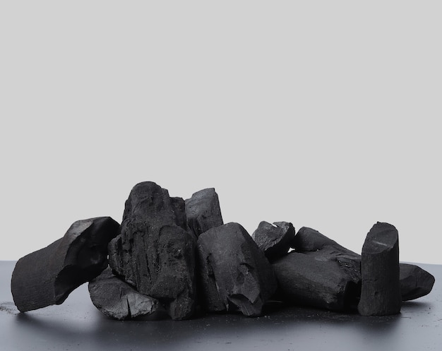 Carvão vegetal. Carvão preto no piso texturizado preto. Usado para churrasqueiras ou outras indústrias. Carvão vegetal de madeira natural. Resíduo de carbono negro produzido por forte aquecimento de madeira. para churrasco tradicional