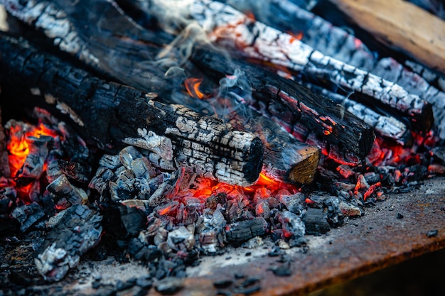 Carvões quentes de lenha closeup e carvão de churrasco de iluminação de cinzas