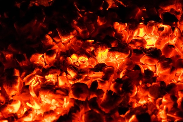 Carvões quentes e ardentes num brasão à noite.