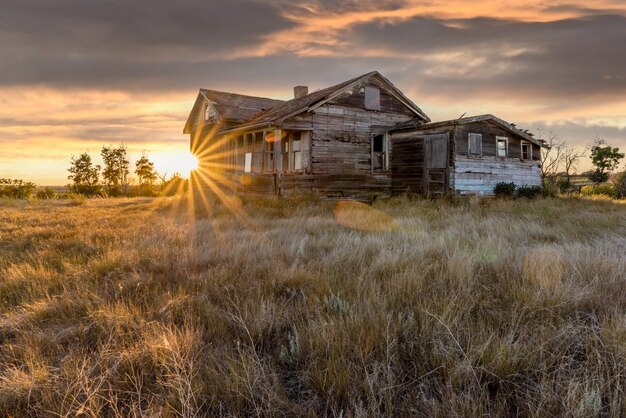 Foto casa abandonada en un corral al atardecer en las praderas canadienses