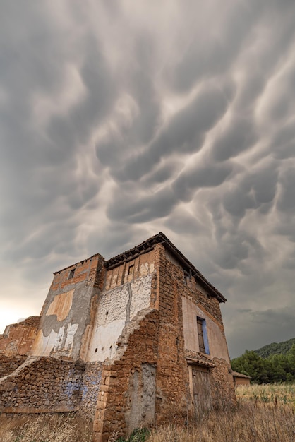 Foto casa abandonada no campo com céu de cúmulos de tempestade