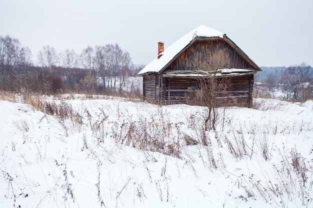 Casa abandonada en pueblo cubierto de nieve